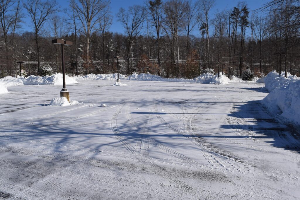 Snow plow clearing residential driveway